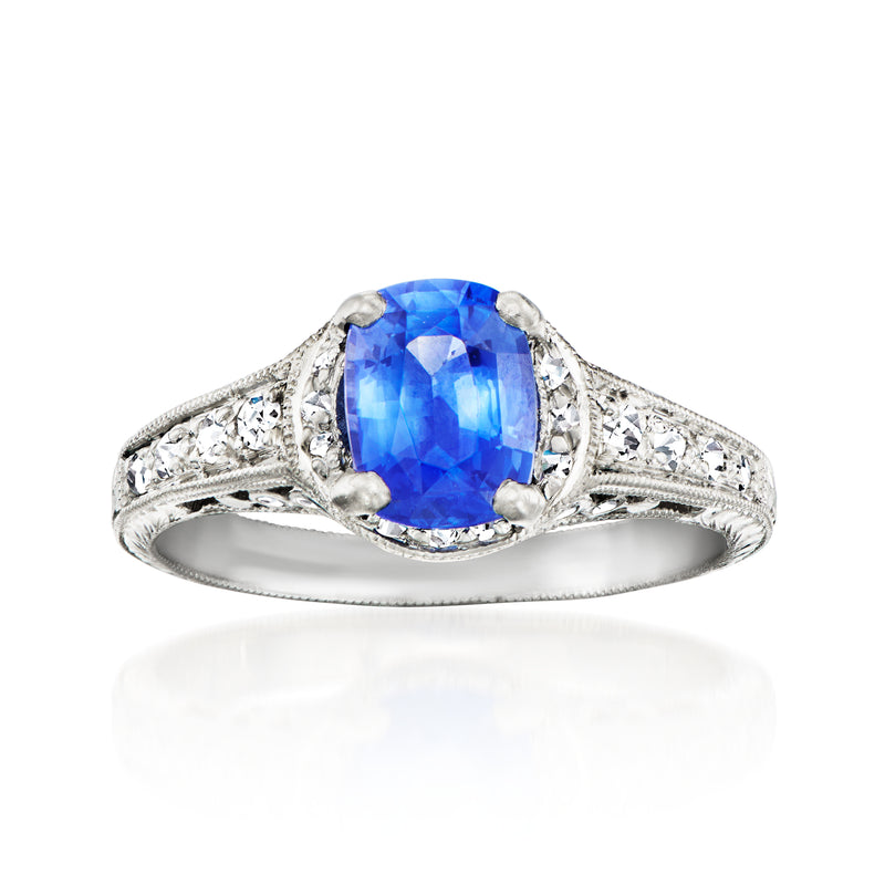 Platinum filigree ring with oval blue sapphire center and diamond accents