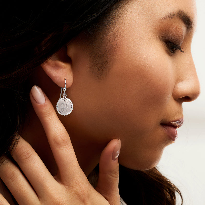 Sterling silver disc drop earrings with monogram initial on ear