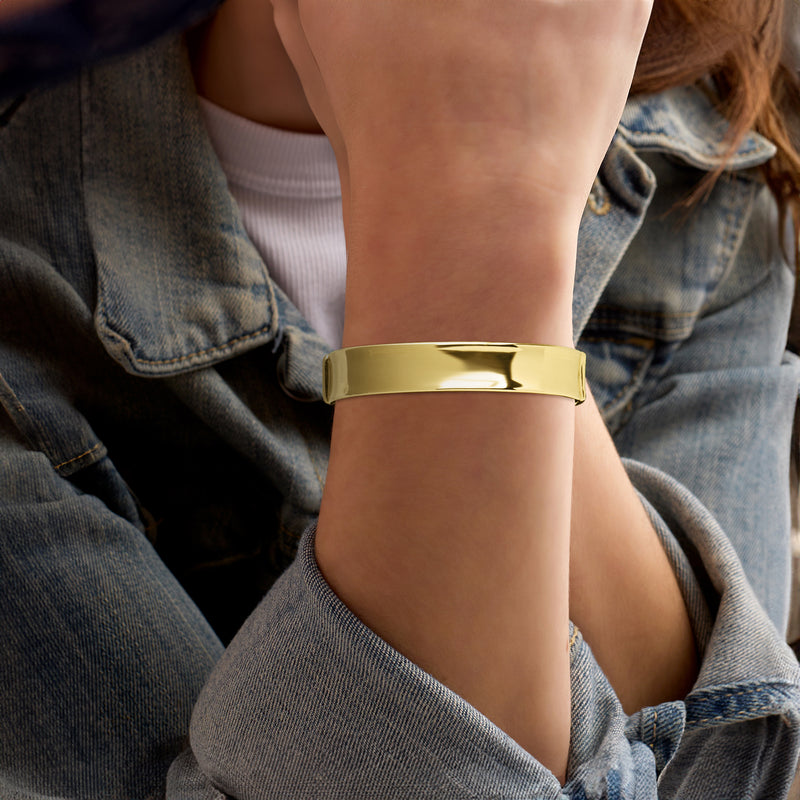 14kt yellow gold wide hinged bangle bracelet on wrist, smooth glossy finish