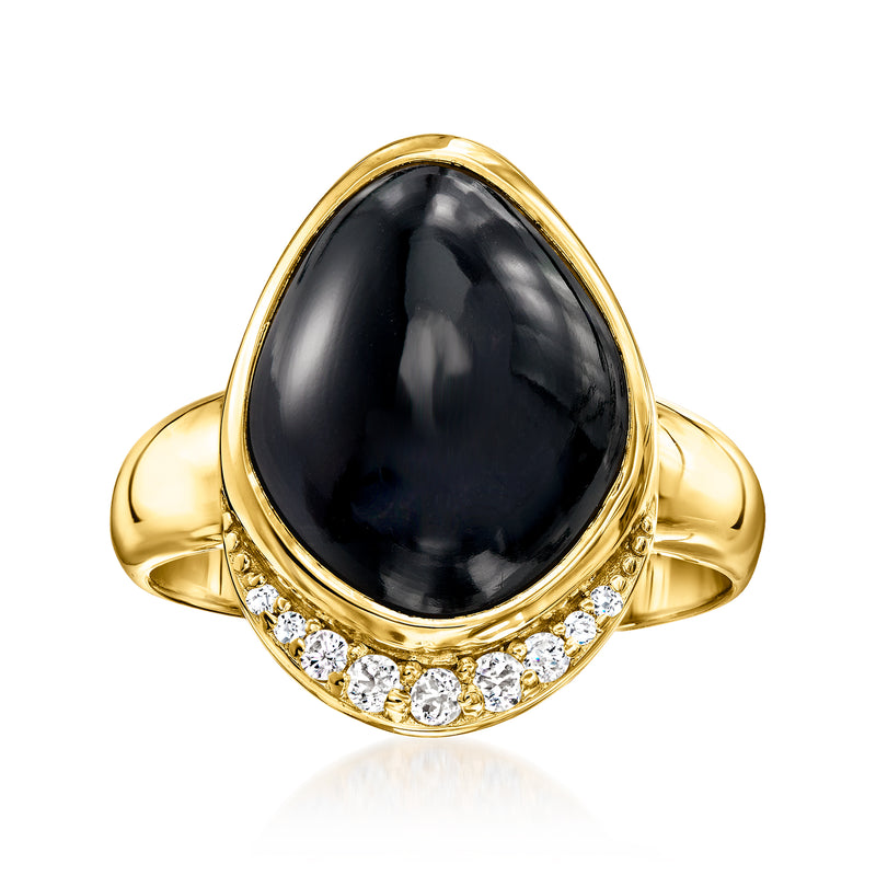Gold-tone ring with dark oval gemstone center and white round stones on lower band