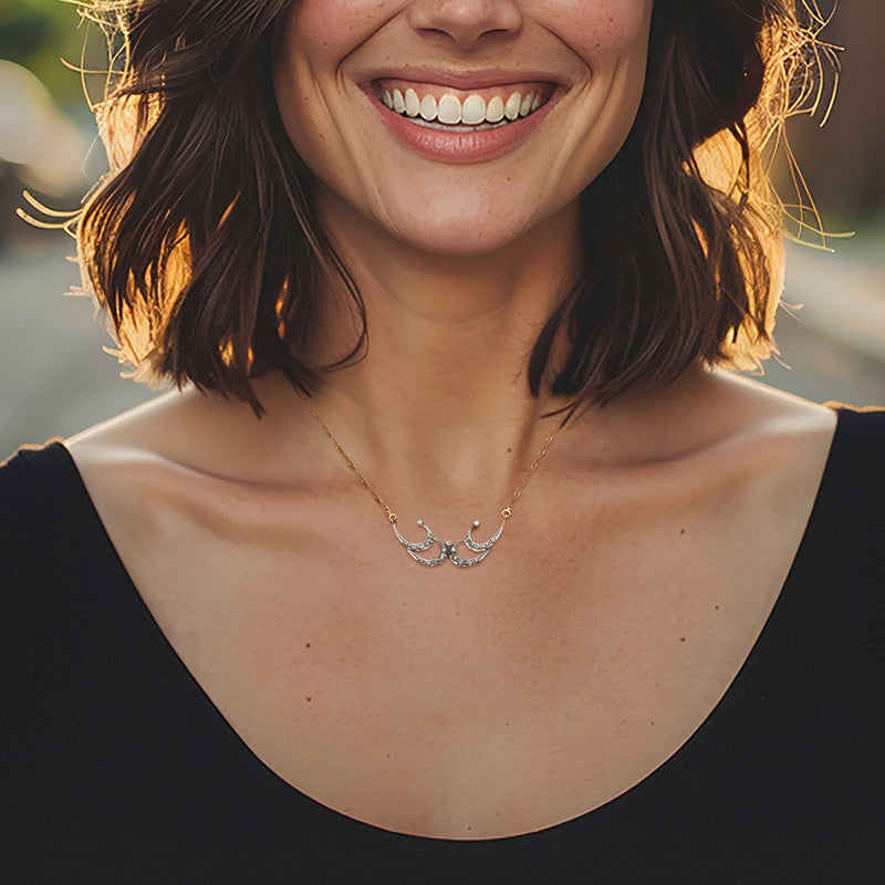 Yellow gold diamond swirl necklace worn at neckline on thin chain
