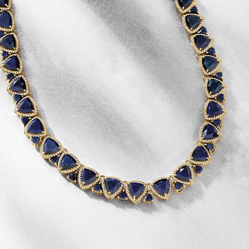Sapphire gemstone tennis necklace with blue oval stones and gold prong settings