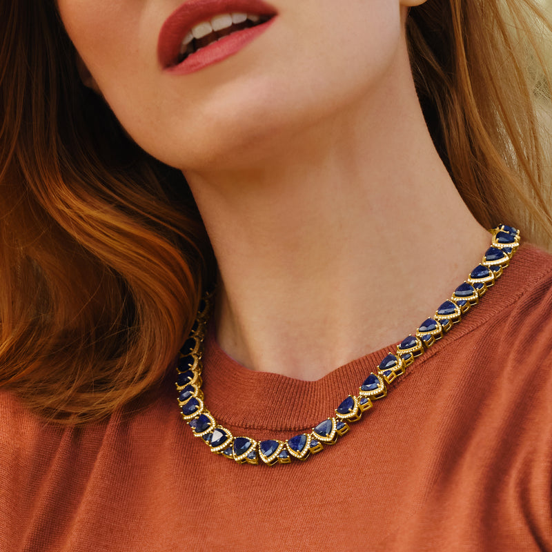Blue sapphire tennis necklace in gold setting with oval stones on collar