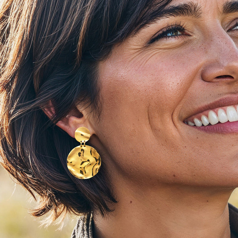 Gold disc drop earrings on model, round hammered discs with small top loop