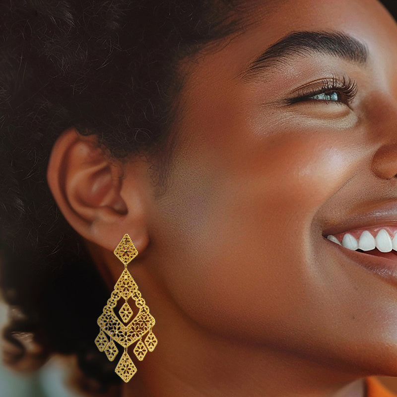 Gold-tone geometric drop earrings on model, dangling lattice diamond shapes