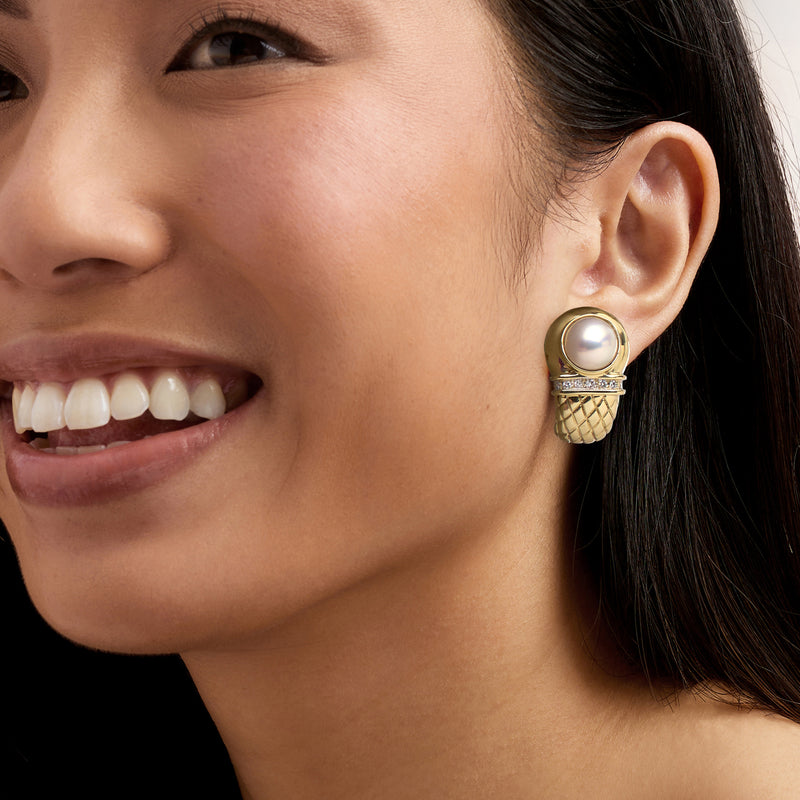 14kt yellow gold mabe pearl and diamond curved earrings on ear with quilted basket