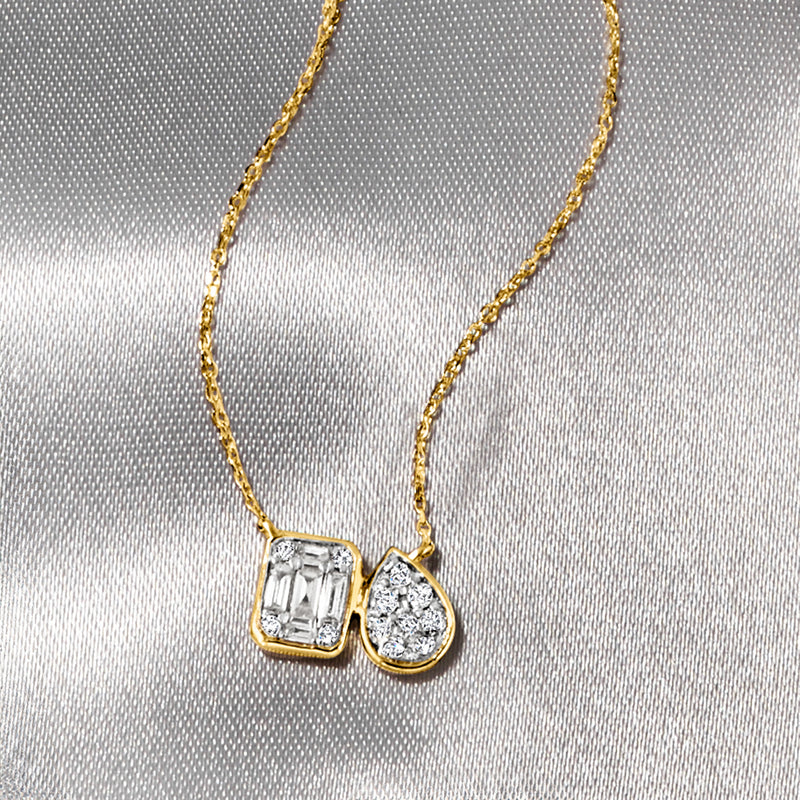 Close-up of yellow gold diamond toi et moi necklace with square and pear stones