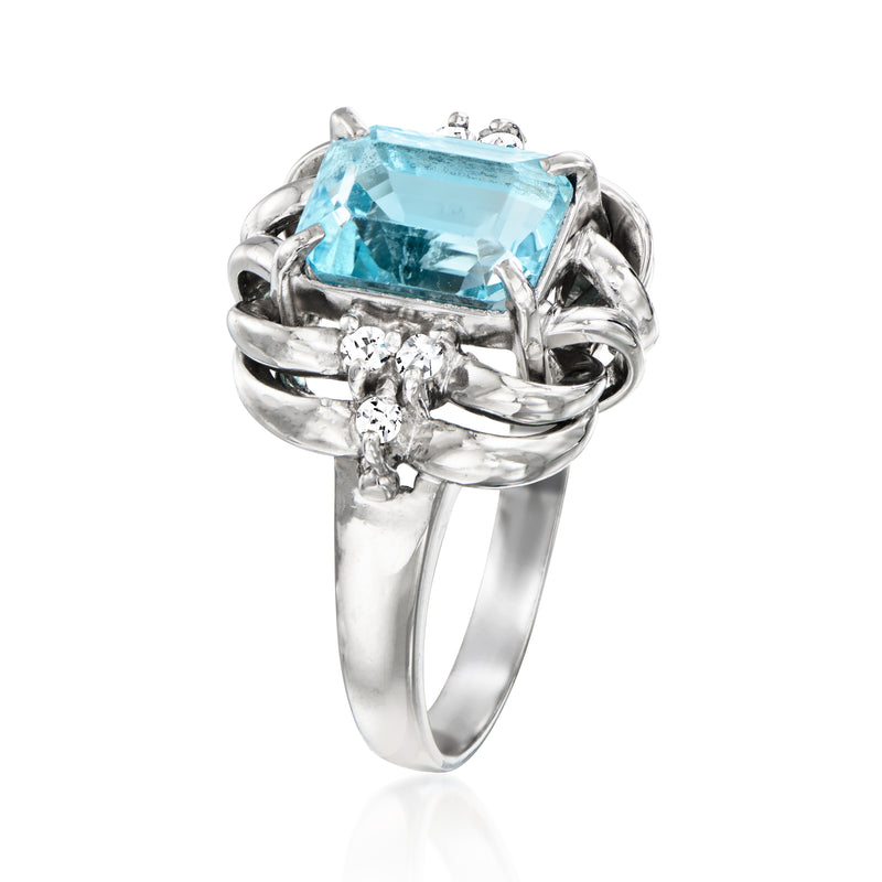 Platinum ring featuring a large sky-blue topaz with diamond cluster halo