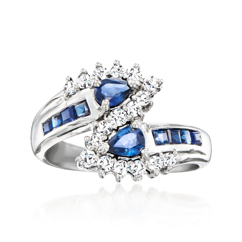 Platinum bypass ring with blue sapphire and diamond cluster, baguette accents