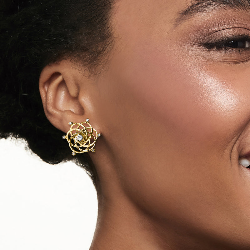 Swirl diamond post earrings worn, 14kt yellow gold with small diamond accents
