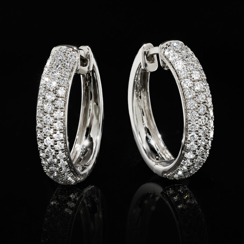 Close-up pave diamond hoop earrings in 14kt white gold with full stone halo