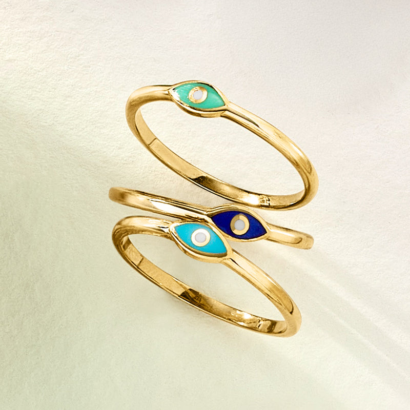 Gold-tone evil eye rings, two stacked with teal and navy blue oval enamel eyes