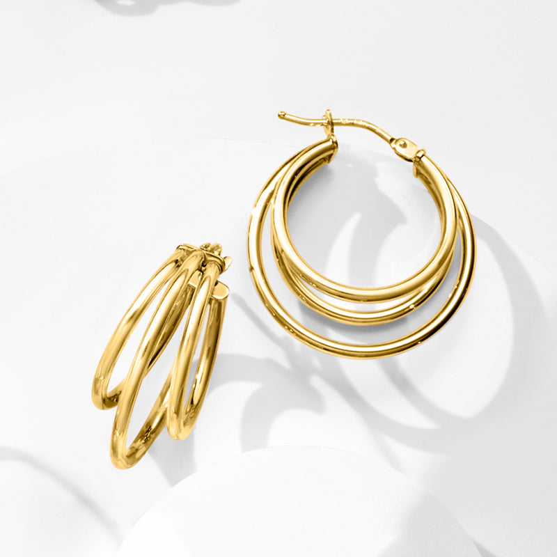 Yellow gold triple-hoop hoop earrings, stacked rings per earring, angled view