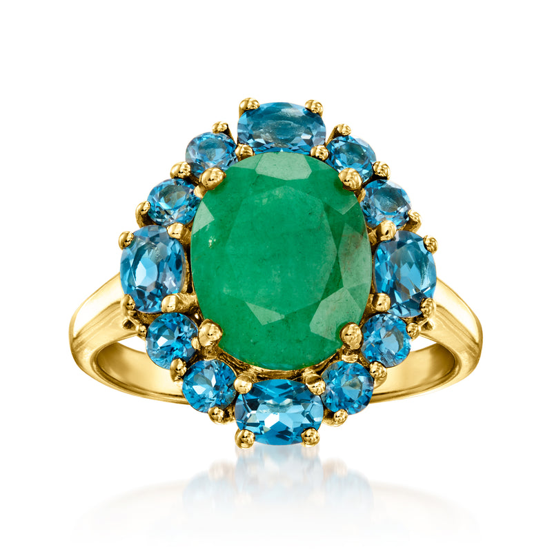 Gold ring with emerald-green oval center stone and blue topaz halo accents