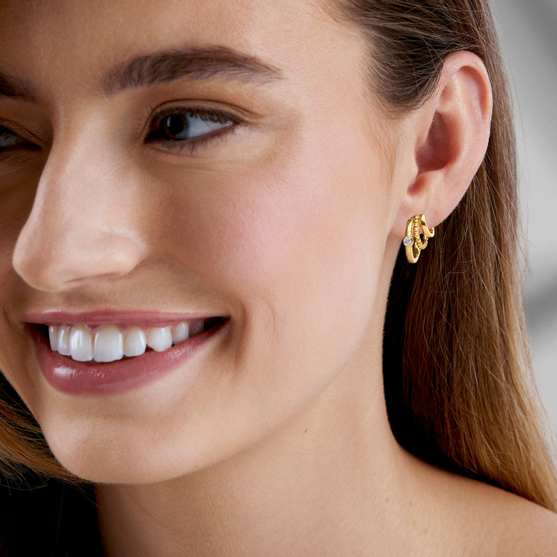 Gold diamond multi-hoop earrings on a model, stacked hoop rings near the ear