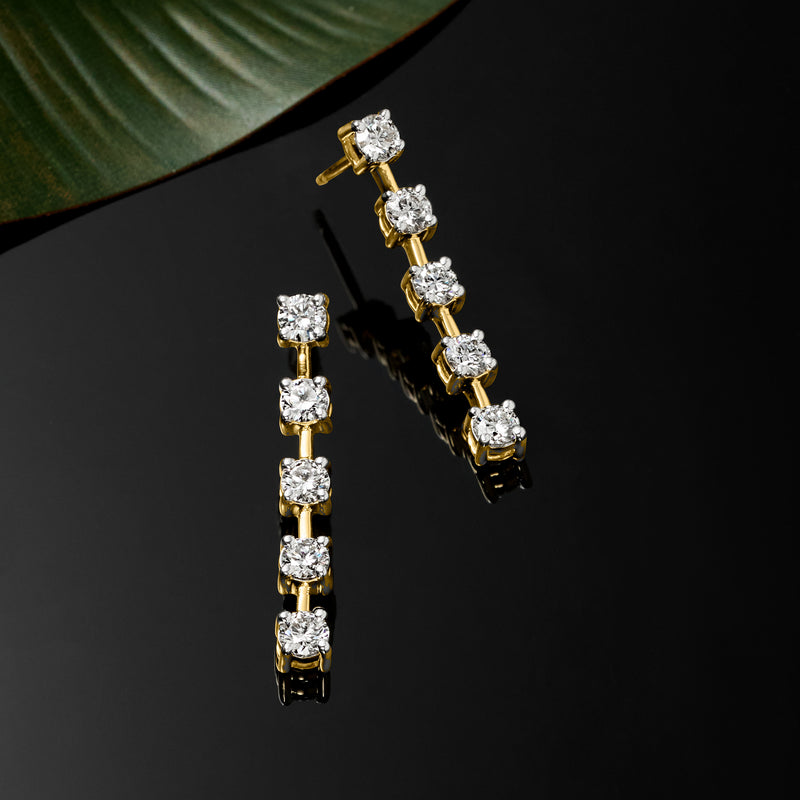 Gold linear drop earrings with five round diamond stones in a vertical row