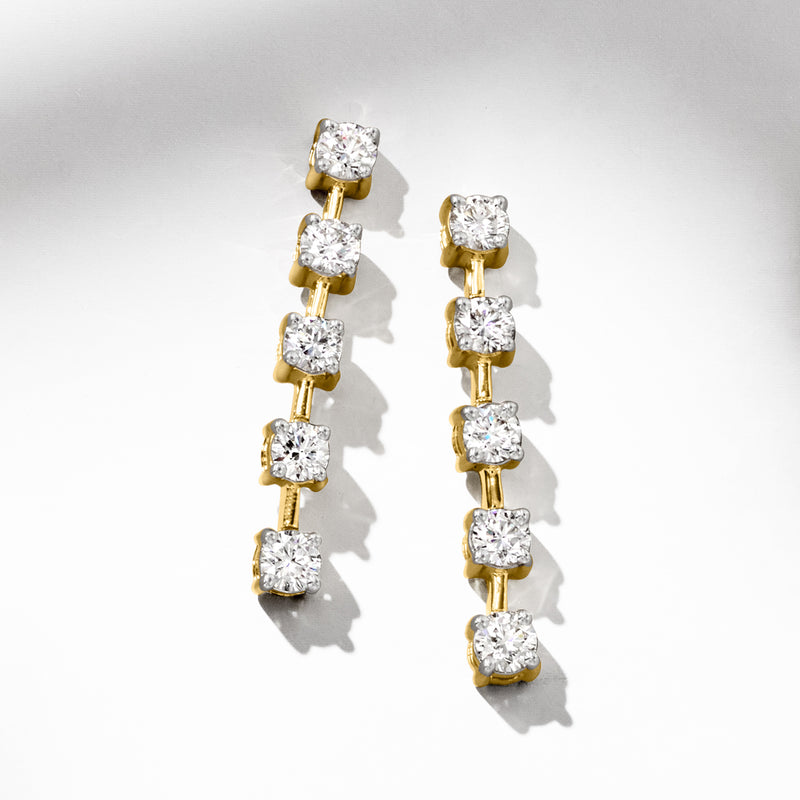 Linear drop earrings in yellow gold with multiple round diamond accents