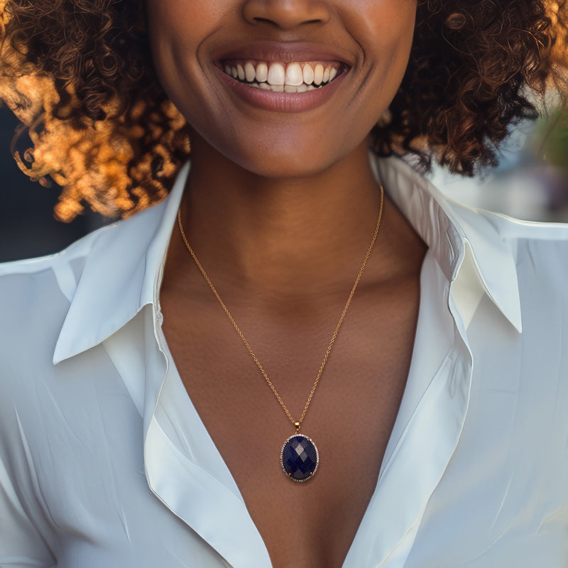 Gold pendant necklace with oval blue sapphire centerpiece on thin chain
