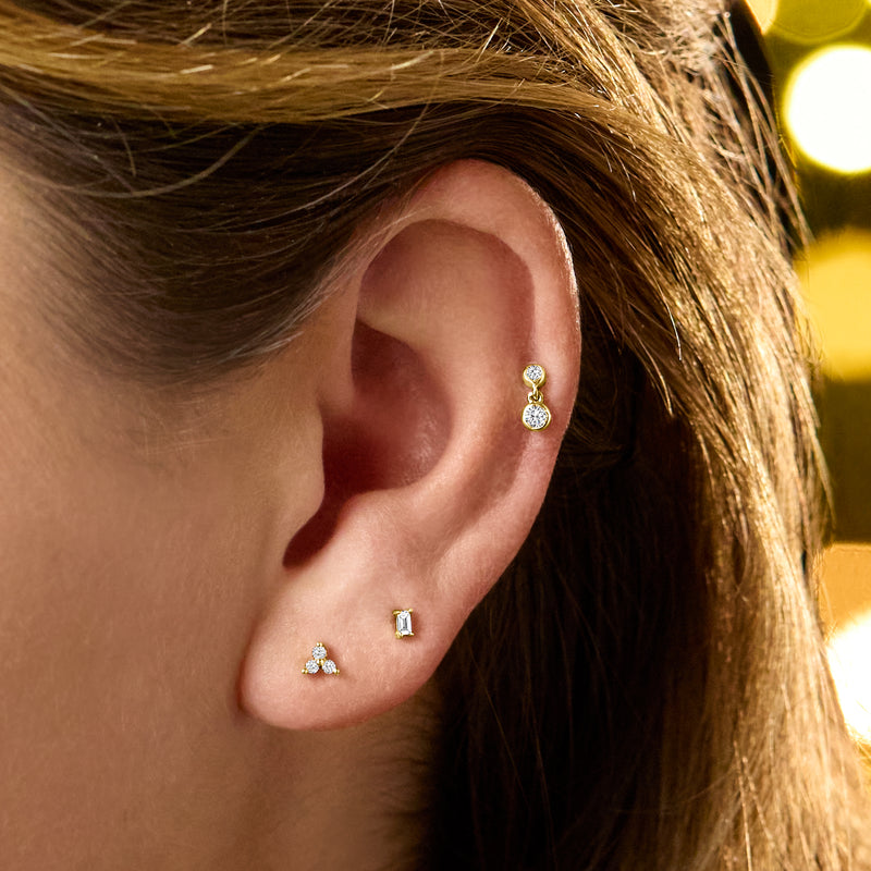 14kt yellow gold two-stone diamond stud earrings on ear, angled view