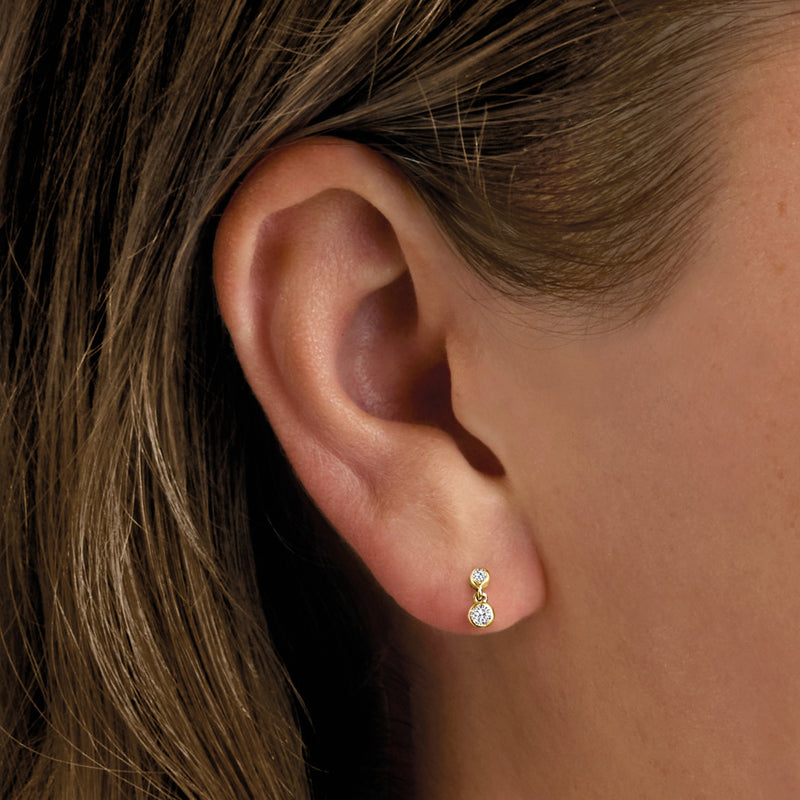 14kt yellow gold two-stone diamond stud earrings on ear, side view