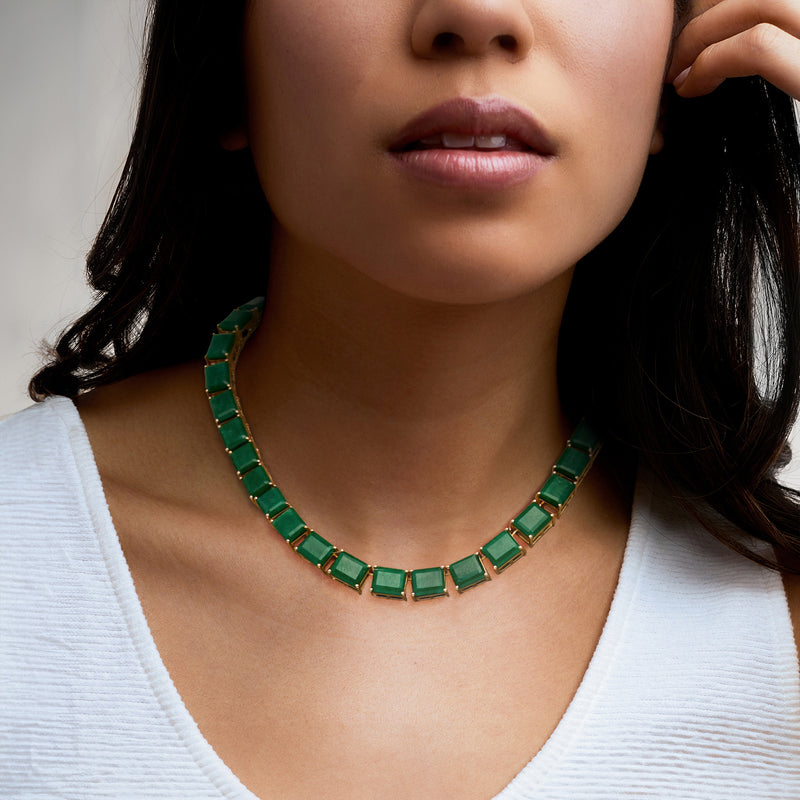 Green emerald-style stone necklace with gold bezel links, worn at collar