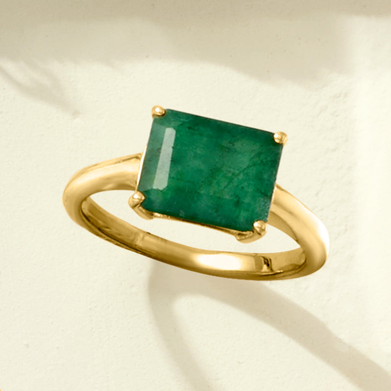 Gold band ring with emerald-green square gemstone in prong setting