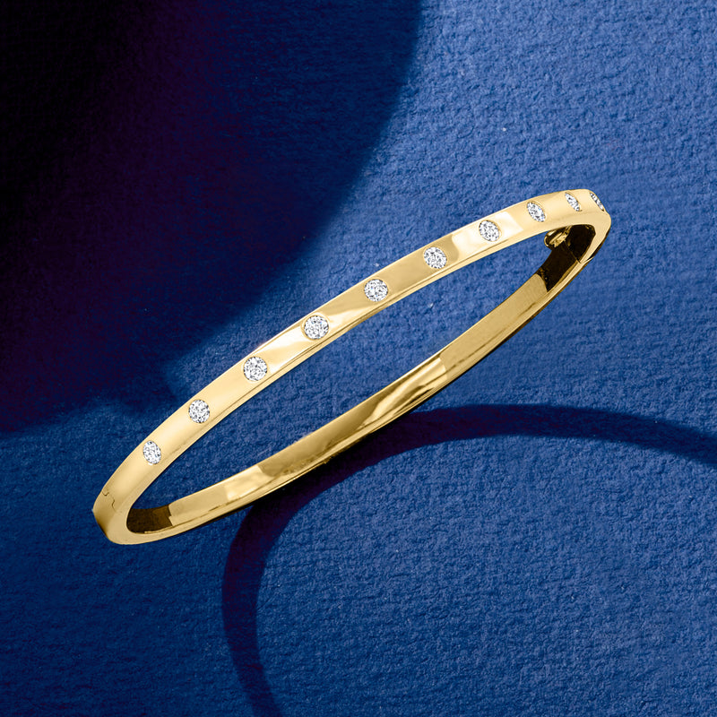 Yellow gold diamond dotted bangle bracelet with small round stones, angled view