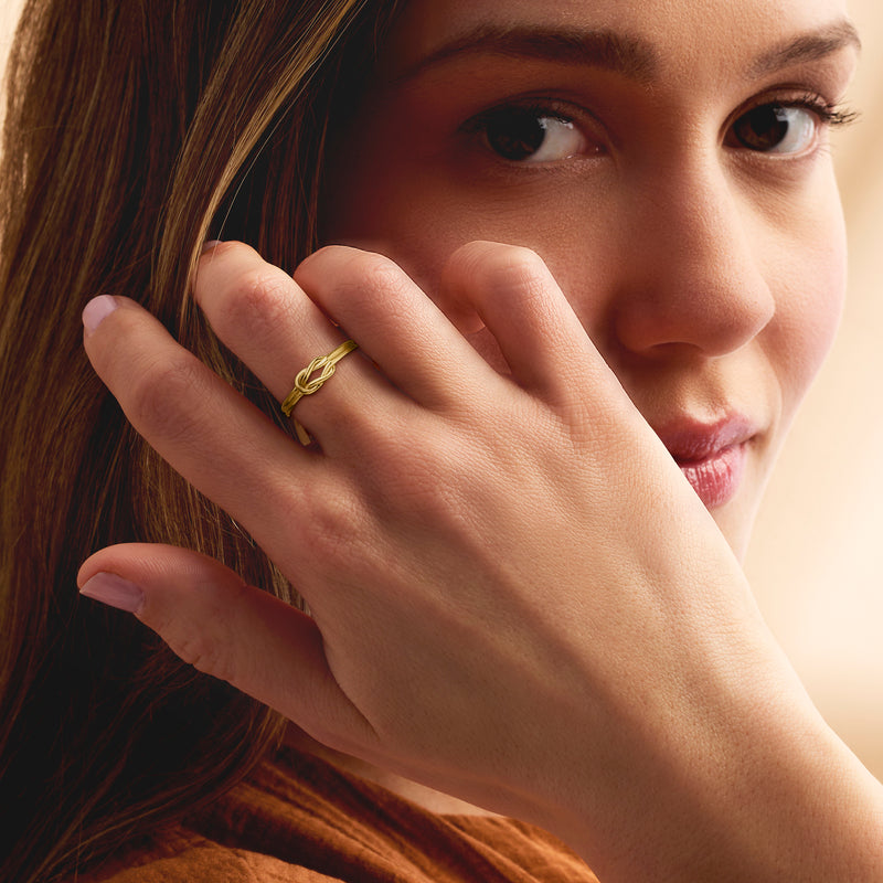 Gold over sterling knot ring worn on finger, braided intertwined top detail