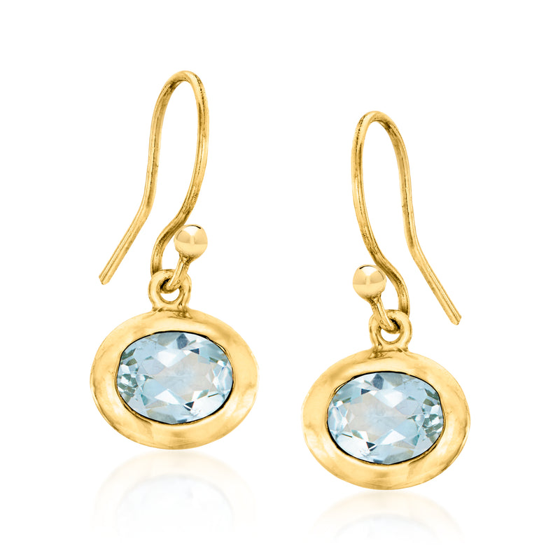 Gold drop earrings with light blue round gemstone in a halo-style setting