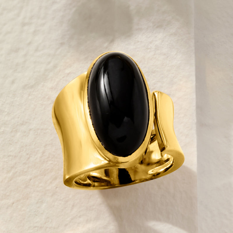 Gold-tone oval onyx wrap ring on a curved base, glossy black center stone bezel