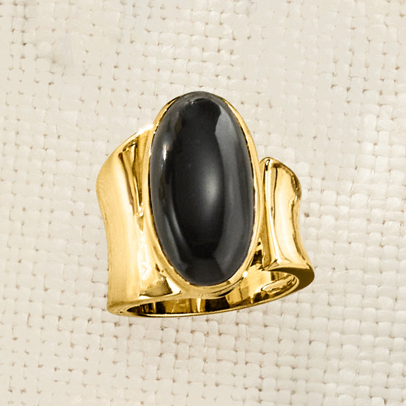 Gold-tone oval onyx wrap ring close-up showing smooth bezel and black glossy stone