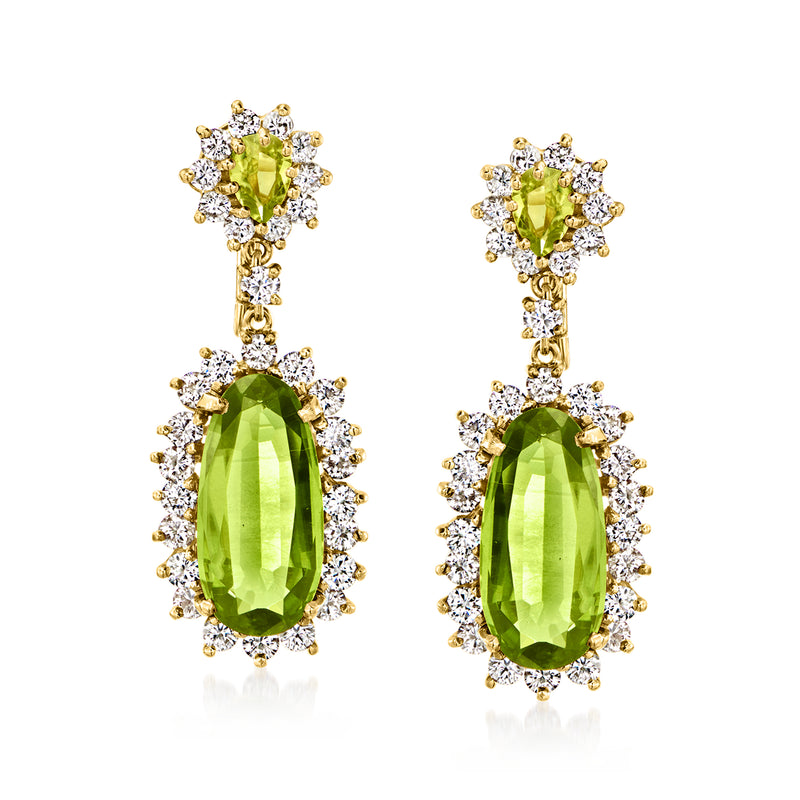 Yellow gold drop earrings with oval peridot, diamond halos, and dangling faceted stones