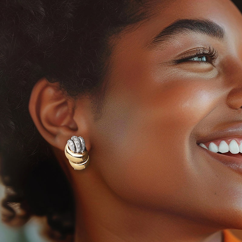 Gold and diamond hoop earrings on ear, with stacked ridges and sparkling center stones