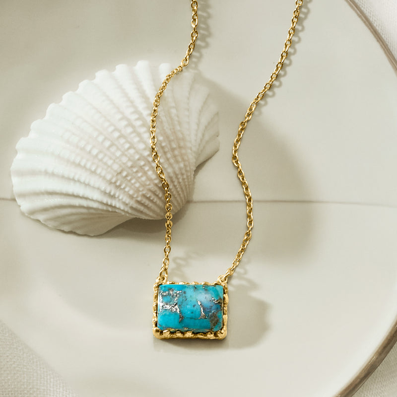 Turquoise square pendant necklace with gold-tone chain and ornate bezel frame