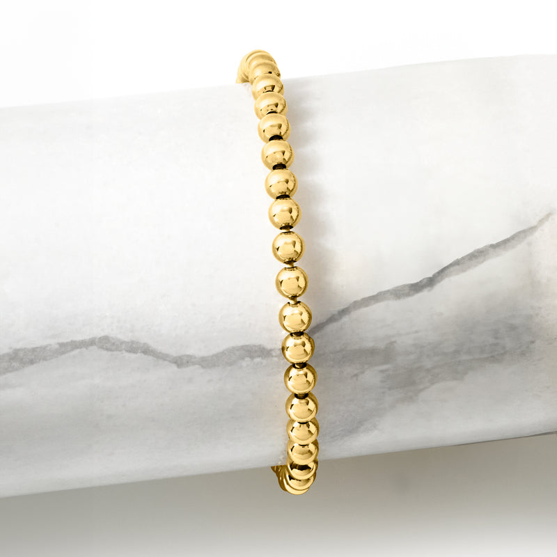 Gold bead stretch bracelet on wrist with small round bead pattern