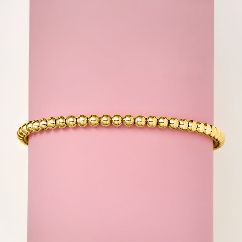 Gold bead stretch bracelet on wrist, tight row of rounded beads