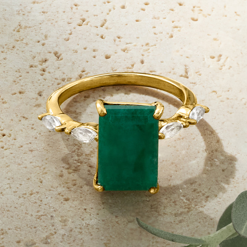 Gold ring with square green center gemstone and clear topaz accents on shoulders