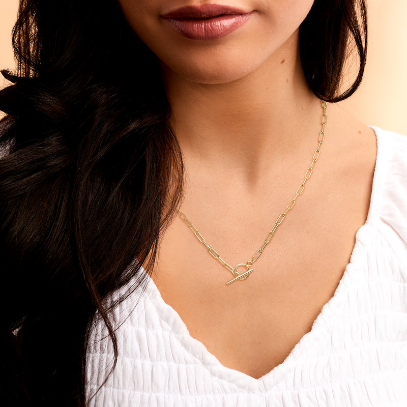 Gold vermeil paper clip link toggle necklace worn on the neck with a white blouse