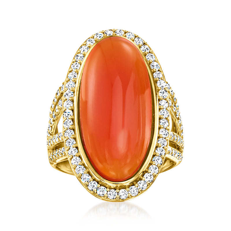 Gold ring with oval orange gemstone and diamond-like halo surround