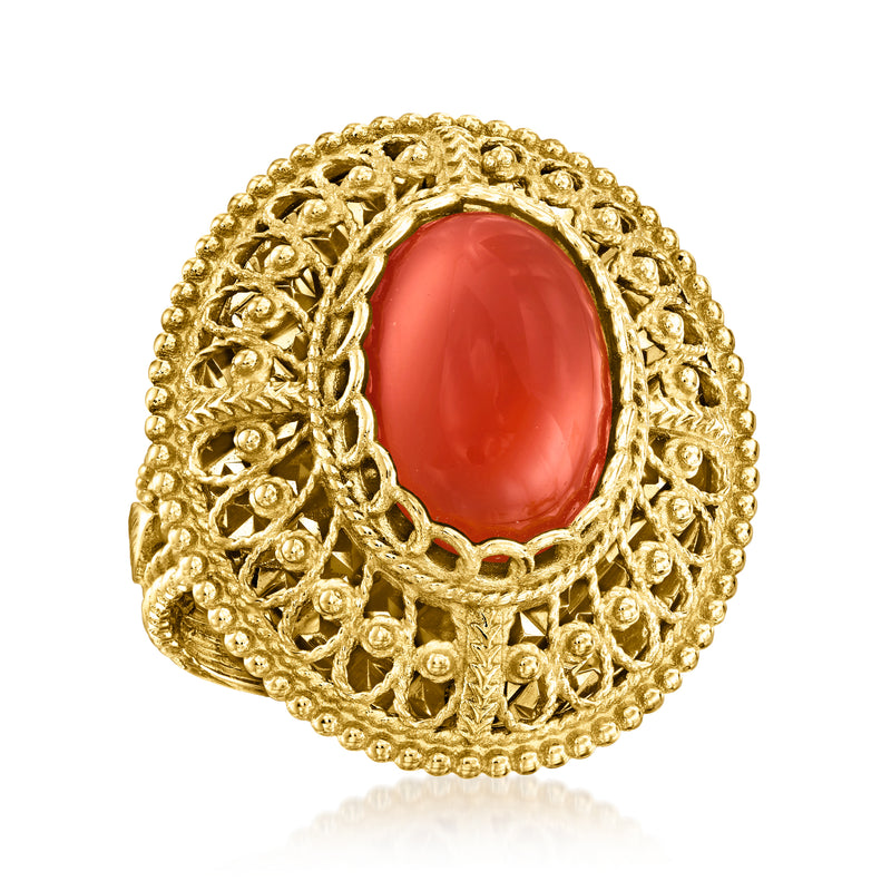 Gold filigree ring with oval red gemstone center and detailed lattice setting