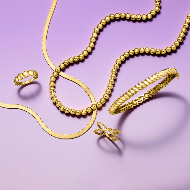 Gold-tone twisted bangle bracelet with small bead details and open end