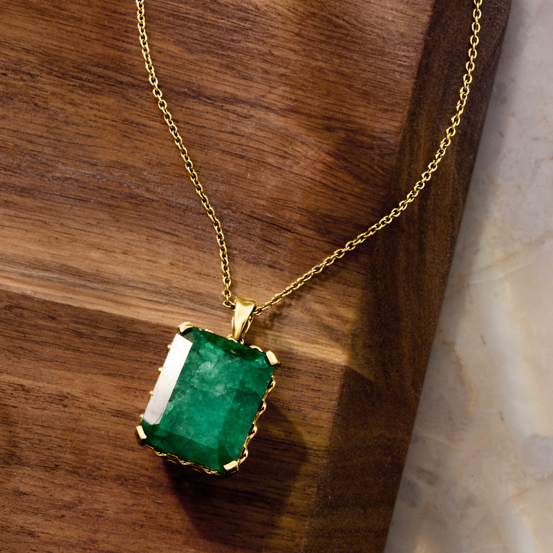 Gold pendant necklace with emerald-cut green gemstone on short link chain