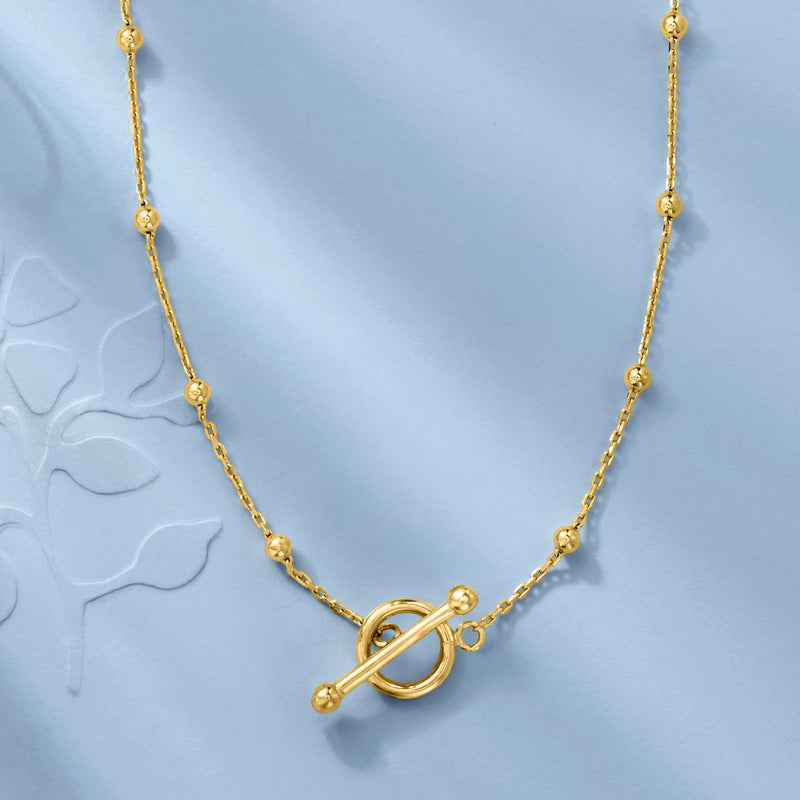Gold bead station toggle necklace with dark oval toggle clasp detail