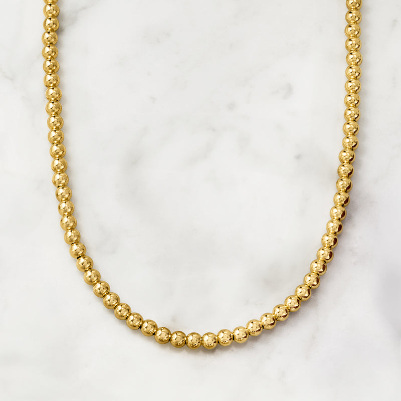 Round gold bead necklace with continuous polished bead chain and no visible pendant