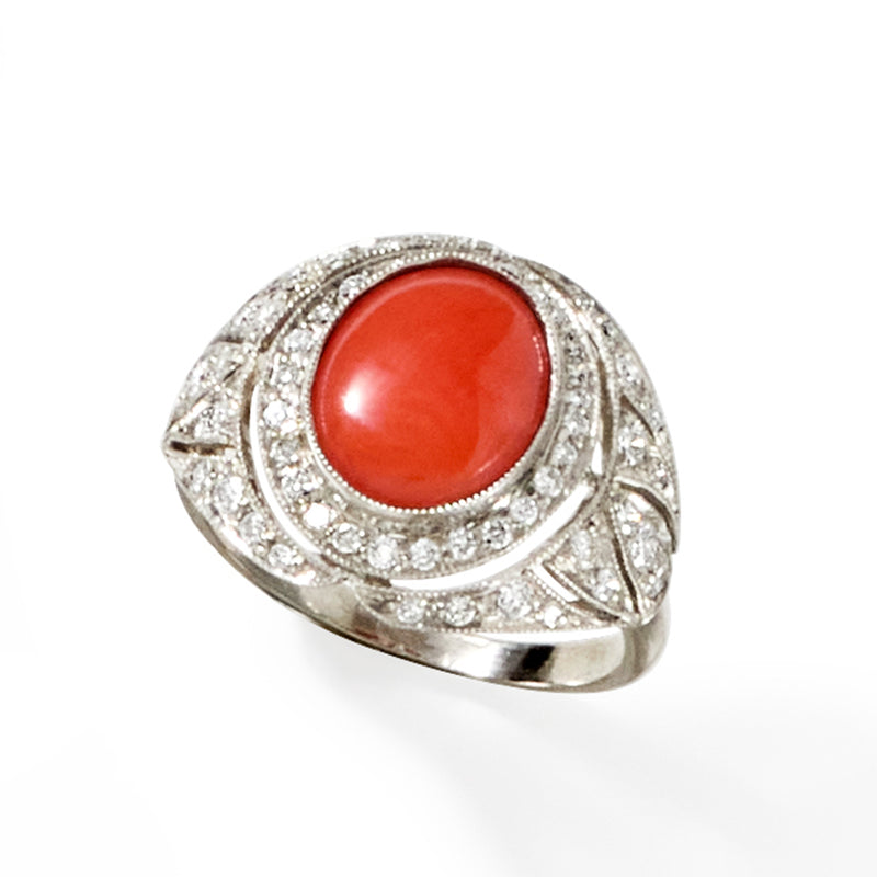 Platinum oval coral cabochon ring with diamond cluster halo and engraved gallery