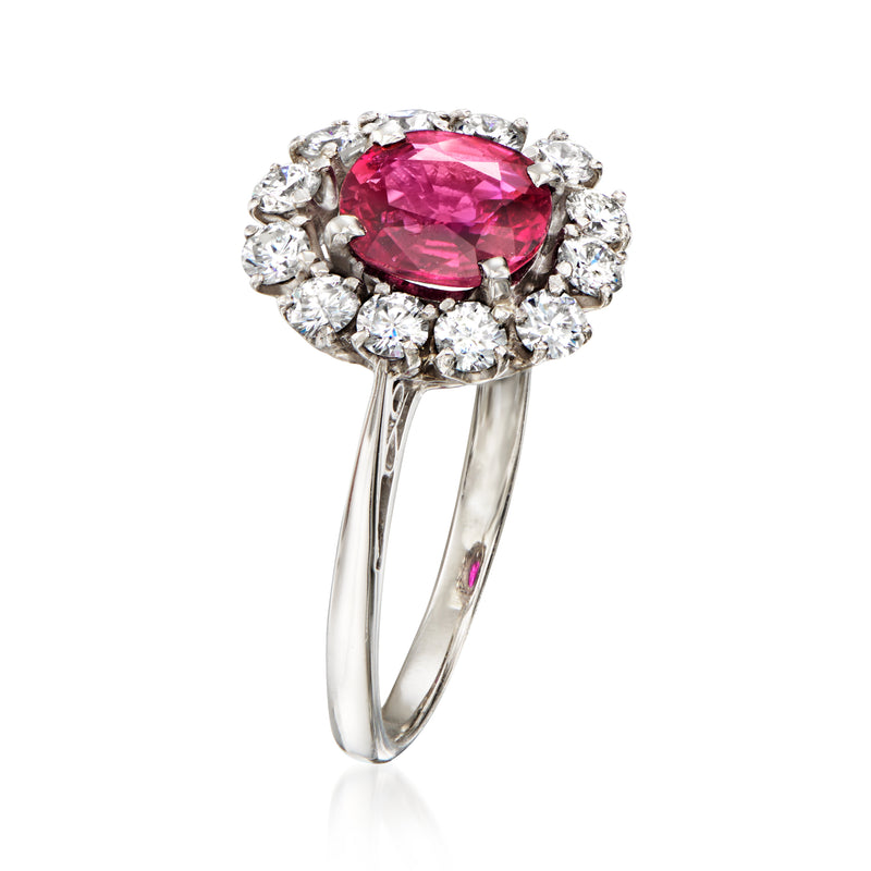 Platinum ring with pink oval ruby and clustered round diamonds around