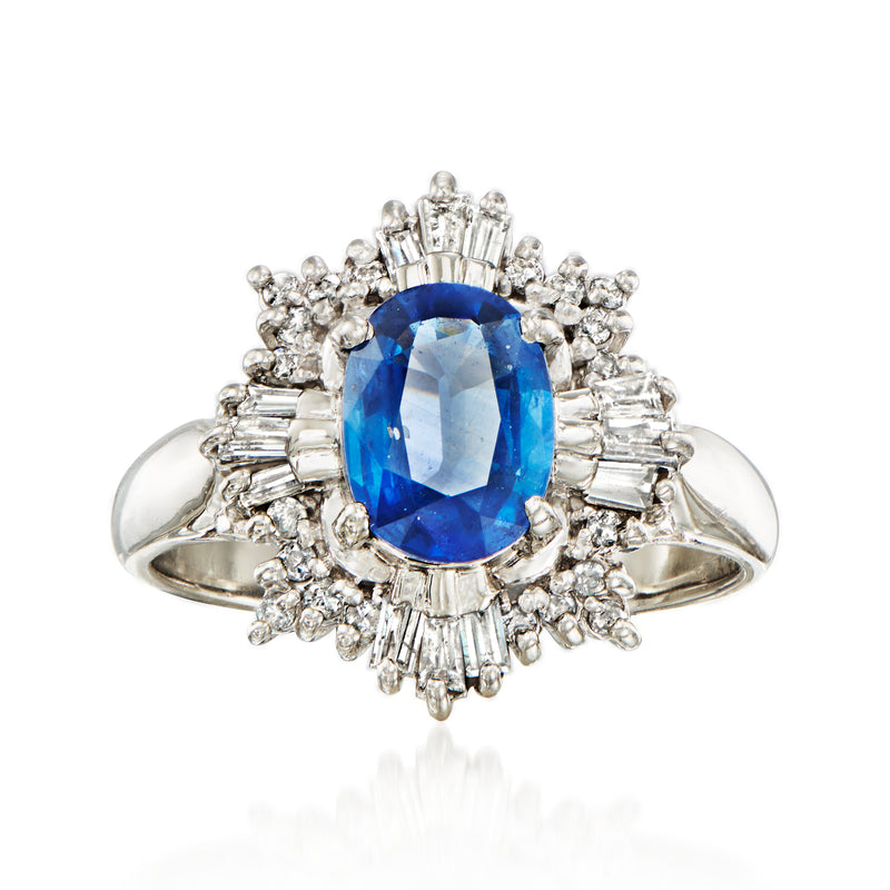 Platinum ring with oval blue sapphire center and diamond halo and baguette accents