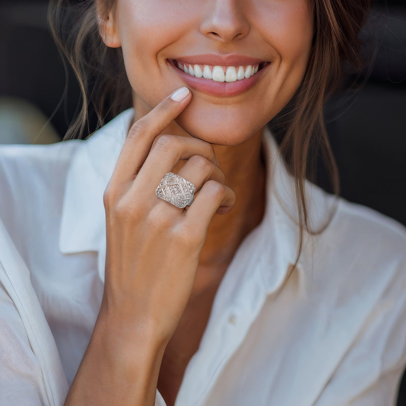 Square-top diamond ring on finger, white-gold band with faceted setting