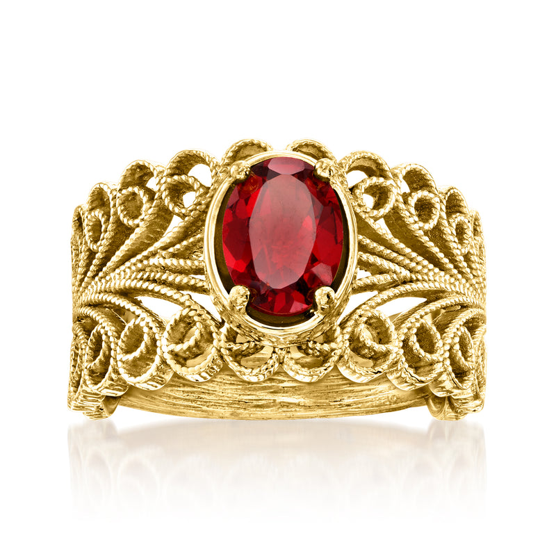 Gold filigree ring with oval red gemstone centerpiece and ornate scrollwork band.
