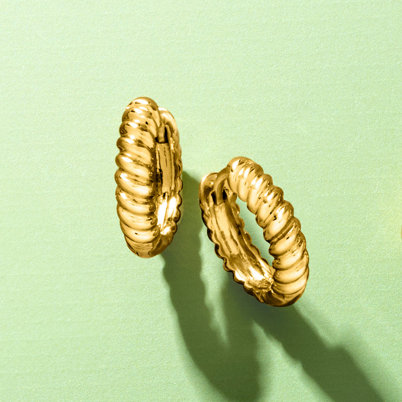 Gold huggie hoop earrings with raised shrimp-like ridges, round profile